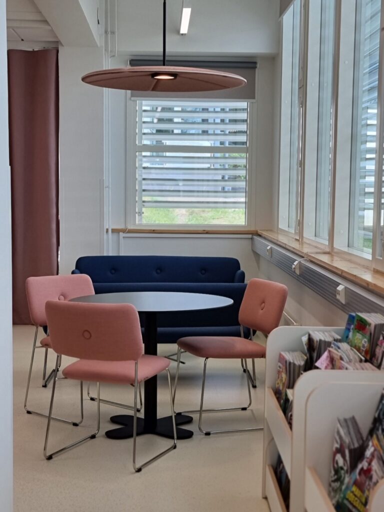 Tornio Kirjasto sisustussuunnittelu nuorten osaston suunnittelu. Vaaleanpunaiset tuolit ja akustiikkavalaisin. Sisu Interior
