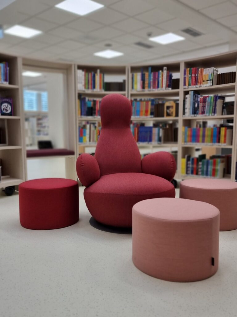 Tornion pehmeät kirjastotokalusteet. Punainen hali tuoli. Sisustussuunnittelu Sisu Interior
